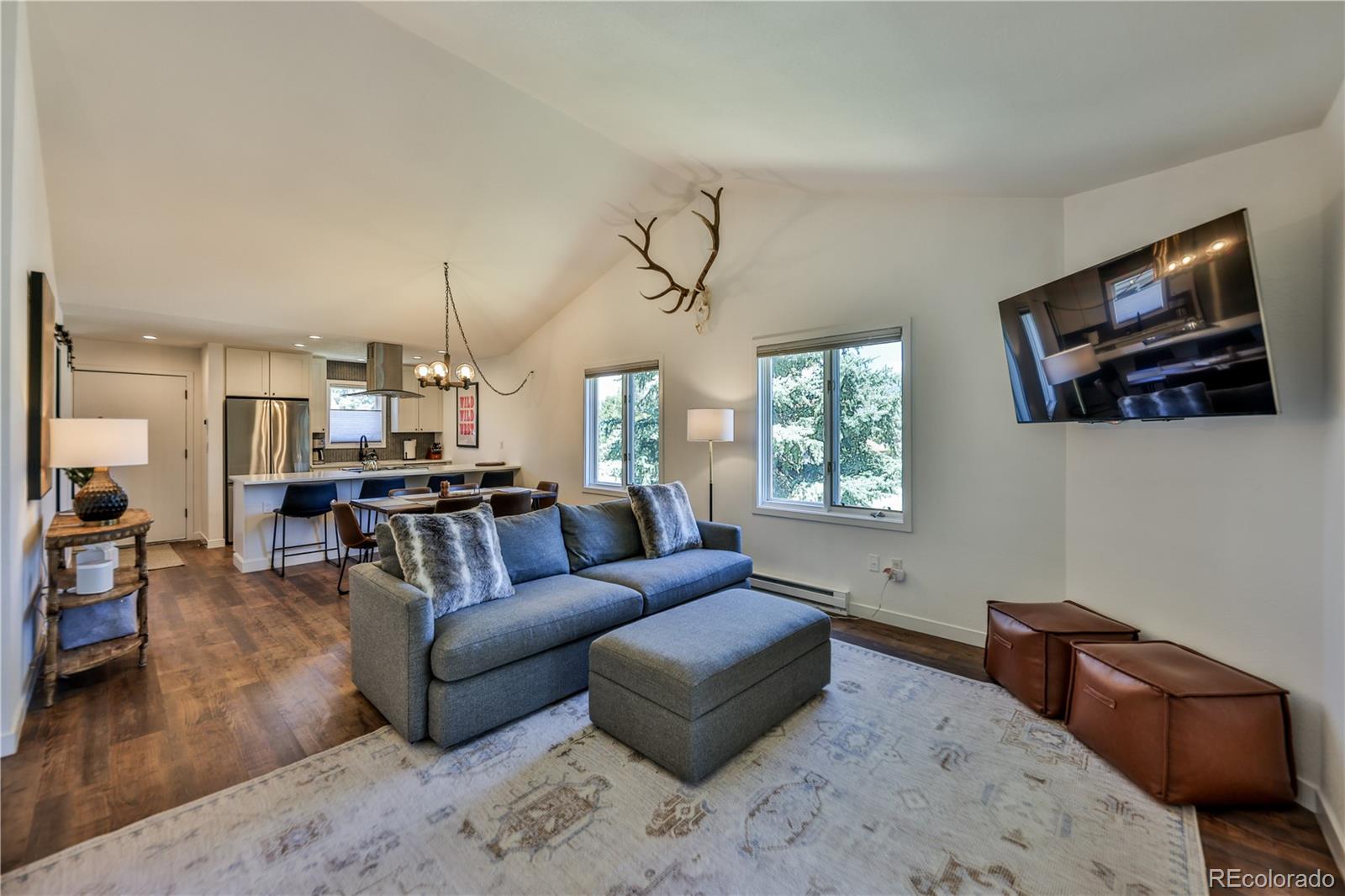 99 Doc Susie Avenue, Unit B6 Fraser, CO 80442 - Photo 4 of 25 a living room with furniture a flat screen tv and kitchen view