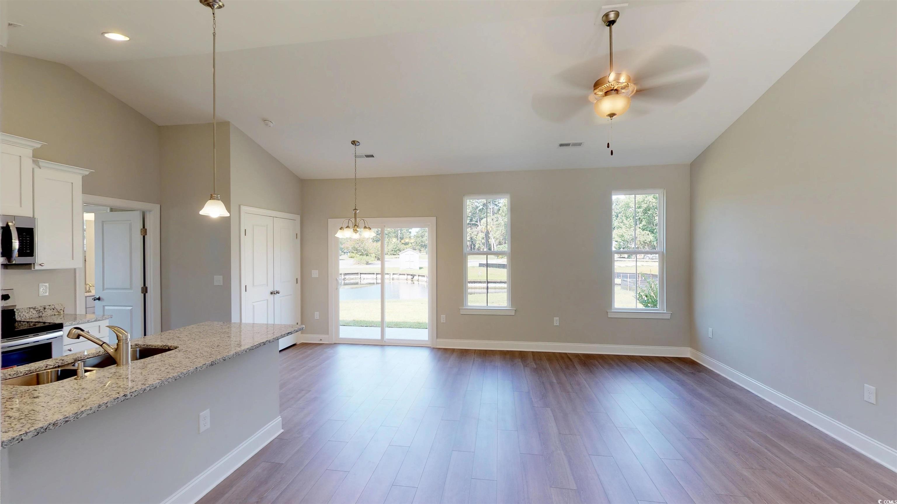 29 Wimbledon Court, Unit WVC 8 Pawleys Island, SC 29585 - Photo 2 of 12 Kitchen with decorative light fixtures, light stone countertops, light wood finished floors, plenty of natural light, and vaulted ceiling
