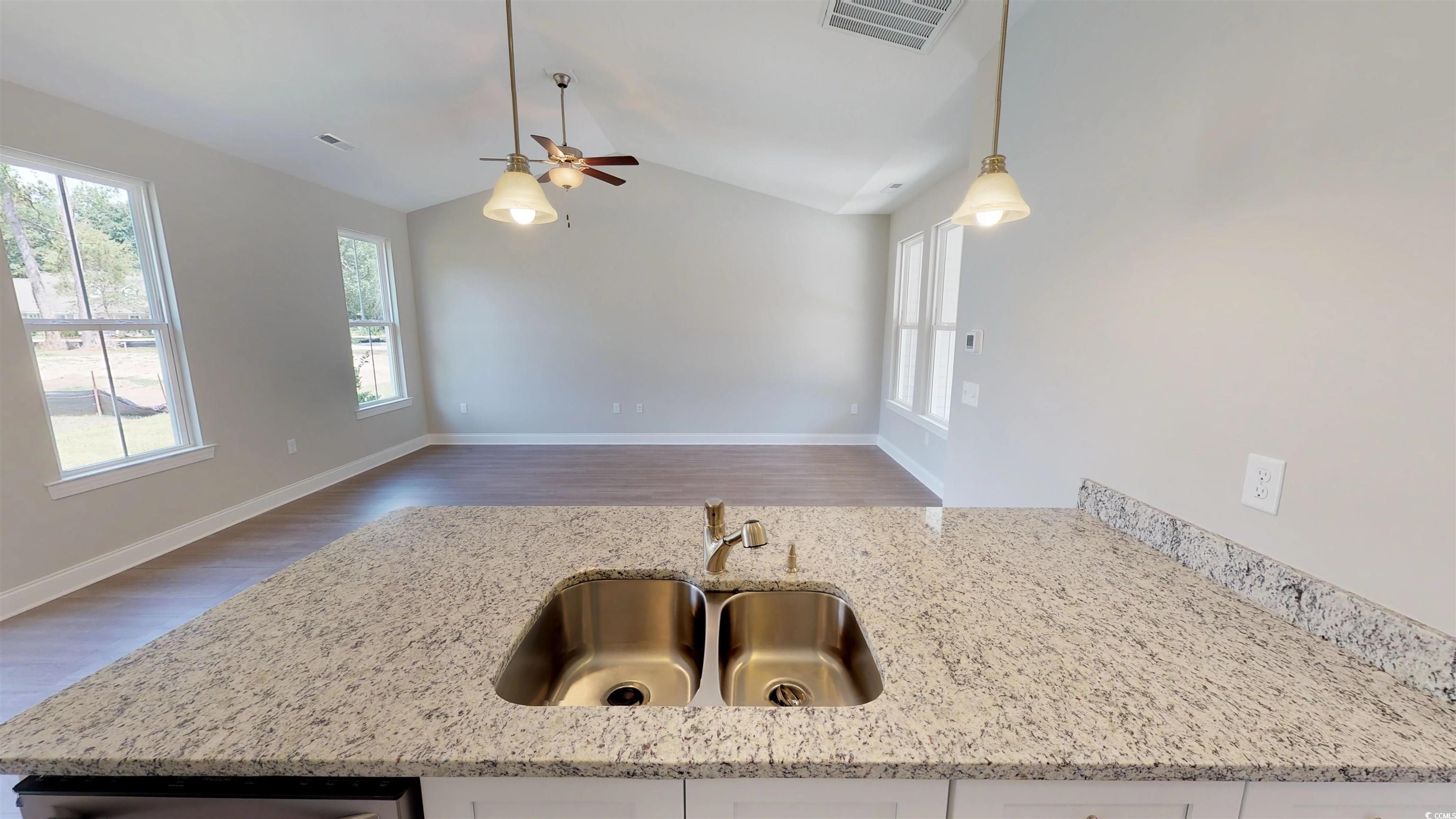 29 Wimbledon Court, Unit WVC 8 Pawleys Island, SC 29585 - Photo 6 of 12 Kitchen with hanging light fixtures, light stone counters, wood finished floors, lofted ceiling, and a ceiling fan
