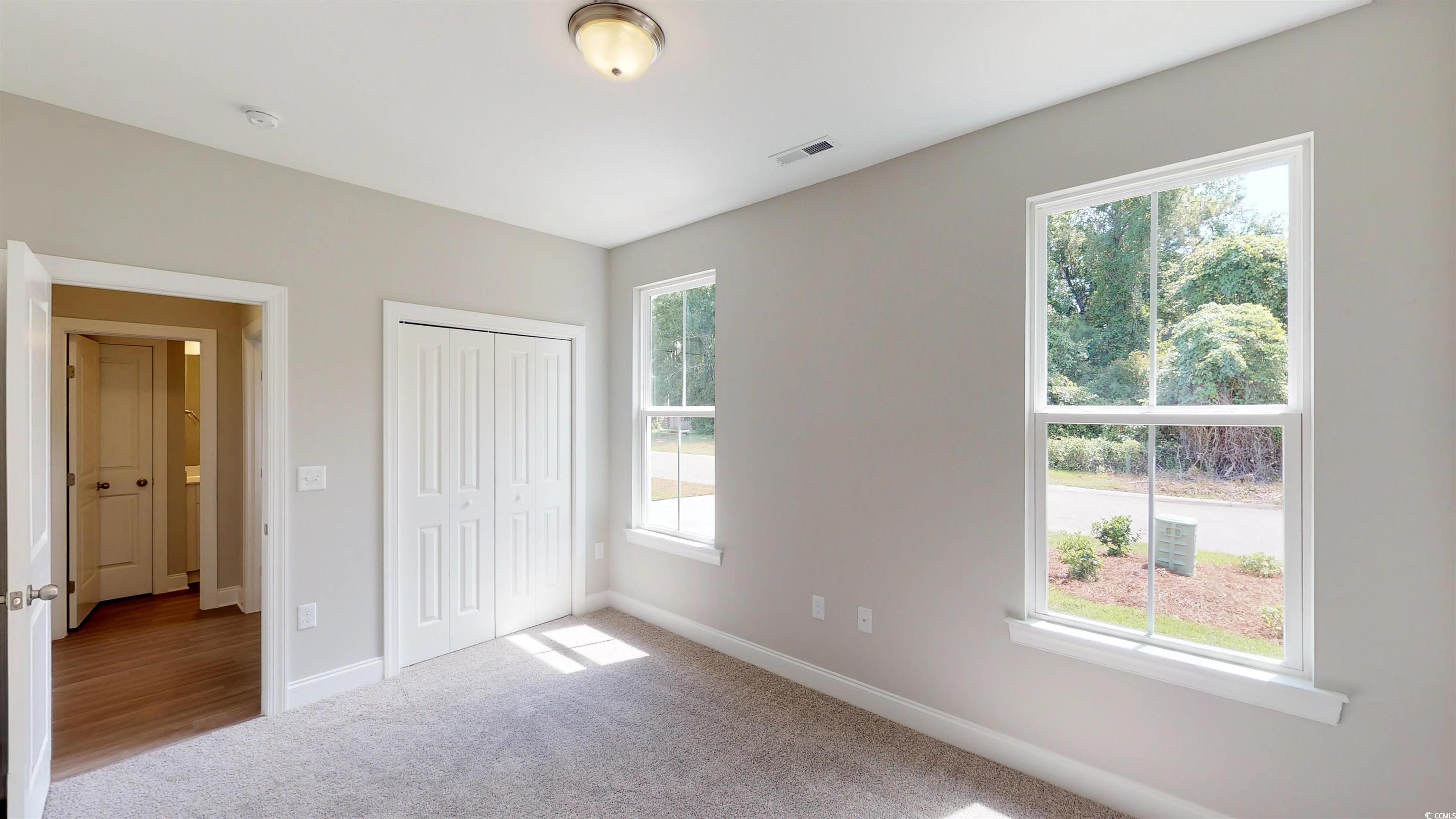 29 Wimbledon Court, Unit WVC 8 Pawleys Island, SC 29585 - Photo 9 of 12 Unfurnished bedroom featuring carpet and a closet