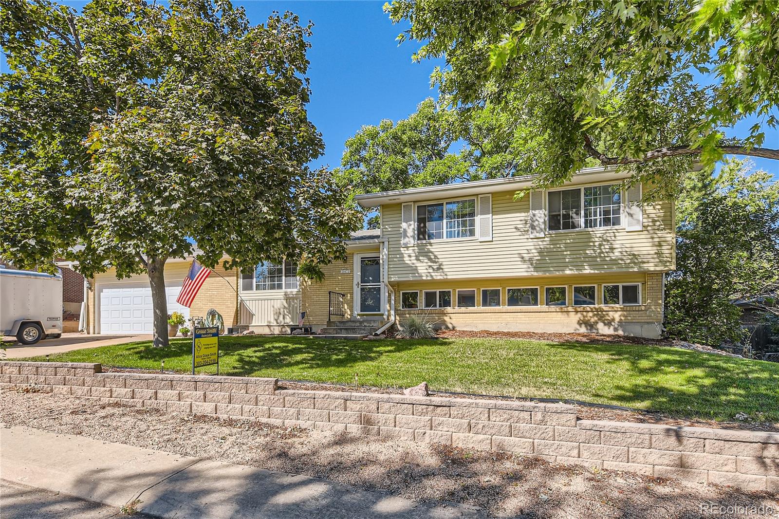 a front view of a house with a yard and potted plants