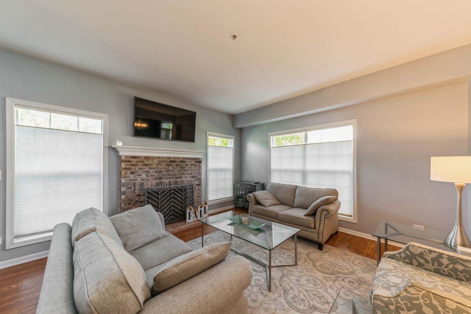 5561 McDonough Road Hoffman Estates, IL 60192 - Photo 2 of 16 a living room with furniture a fireplace and a flat screen tv