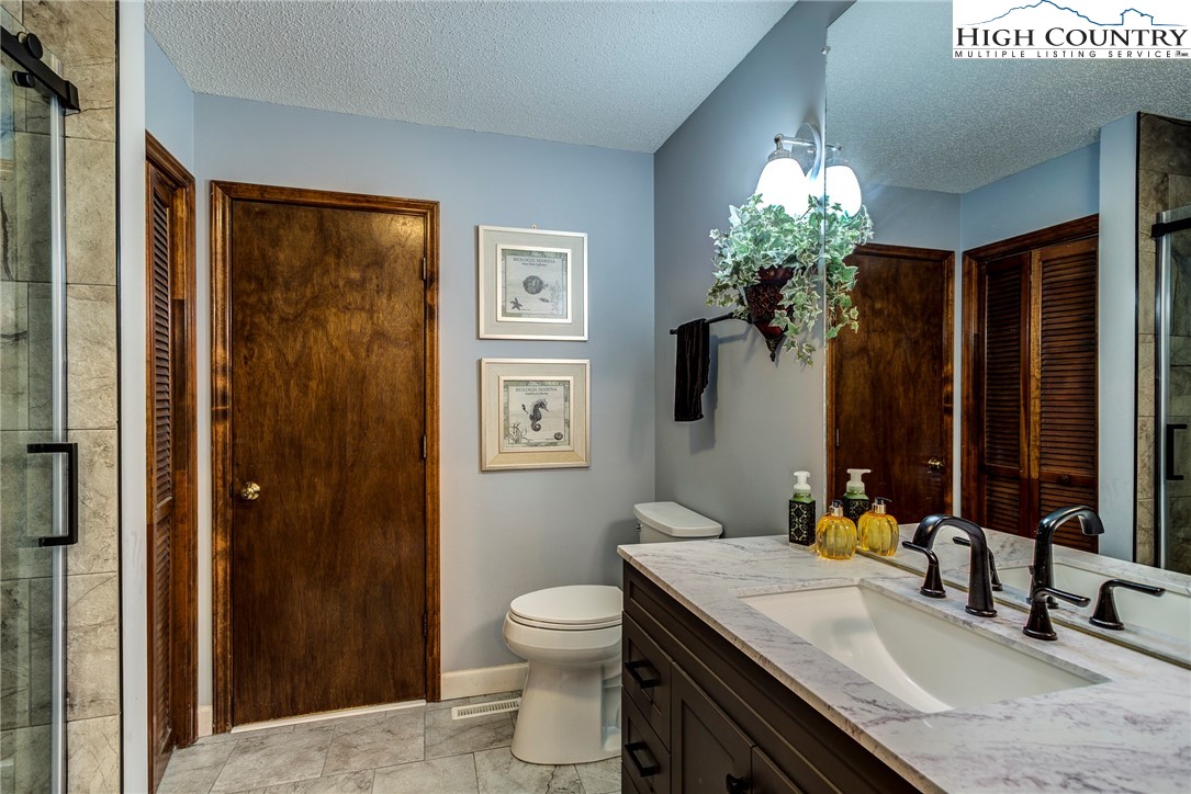 249 Red Bird Lane Glade Valley, NC 28627 - Photo 21 of 41 a bathroom with a granite countertop sink toilet and shower