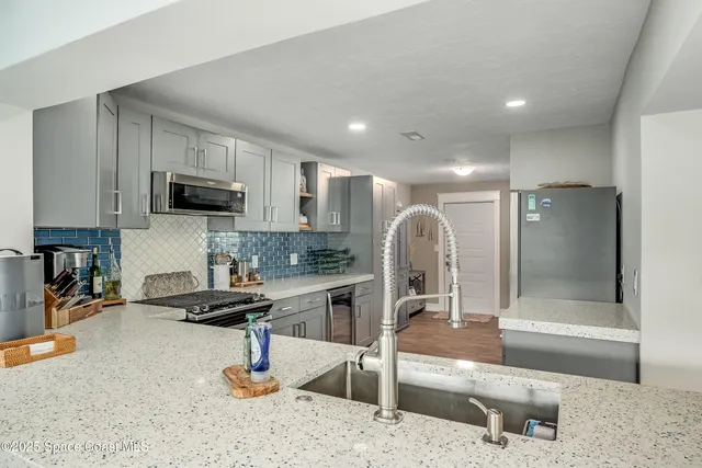 a open kitchen with stainless steel appliances granite countertop a sink and cabinets