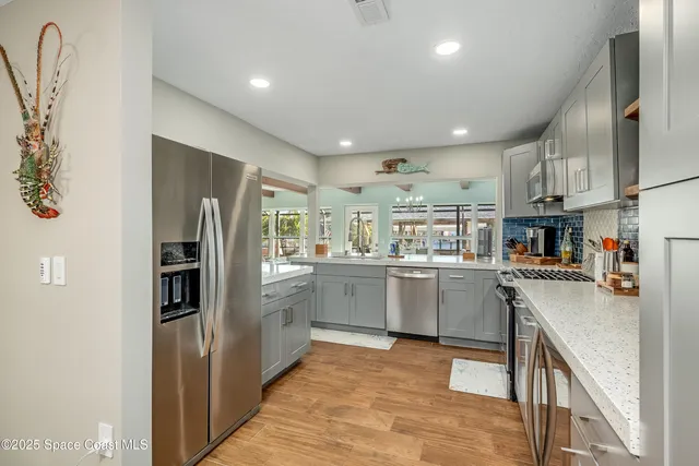 a kitchen with kitchen island granite countertop a sink window and cabinets