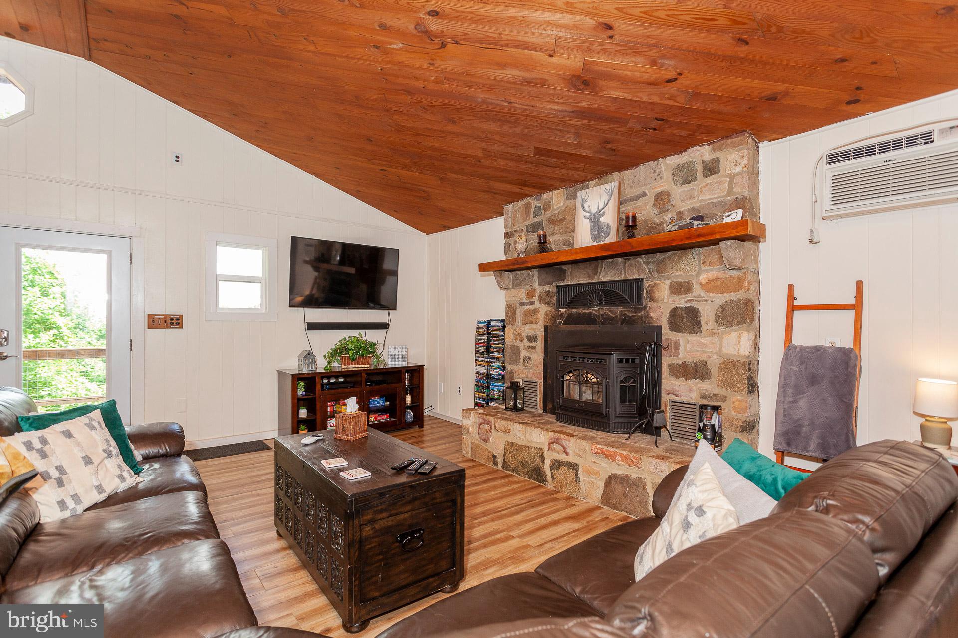2668 Pine Grove Road Stanley, VA 22851 - Photo 18 of 35 a living room with furniture a fireplace and a flat screen tv