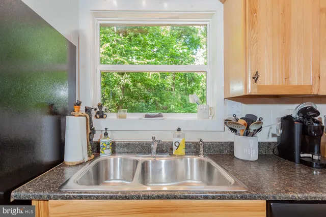 a kitchen with a granite countertop sink and window