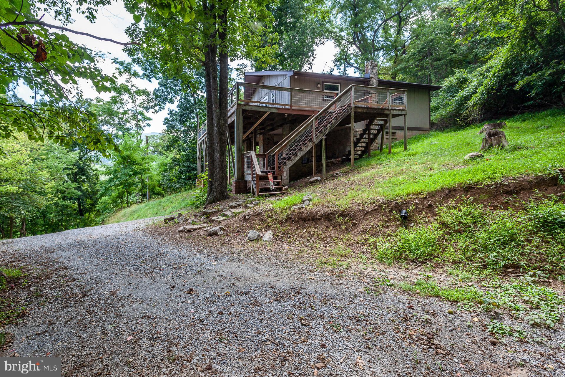 2668 Pine Grove Road Stanley, VA 22851 - Photo 5 of 35 a view of a wooden house with a yard and large trees