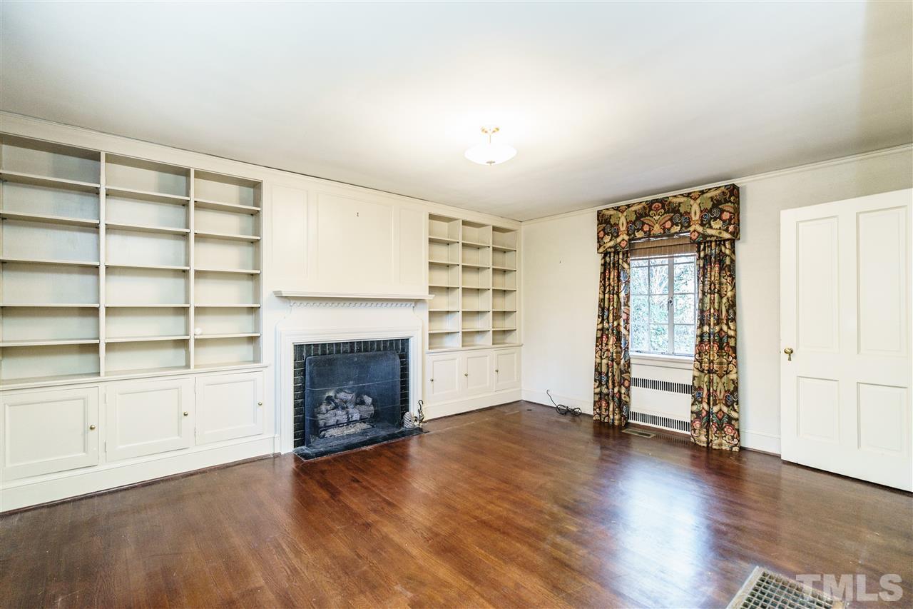 2515 White Oak Road Raleigh, NC 27609 - Photo 11 of 25 an empty room with wooden floor fireplace and windows