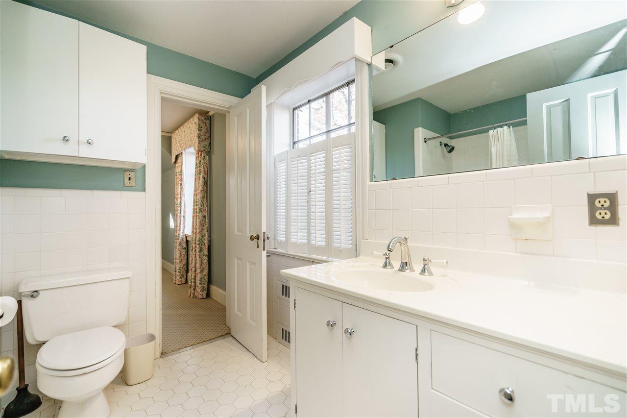 2515 White Oak Road Raleigh, NC 27609 - Photo 14 of 25 a bathroom with a sink a toilet and a large mirror