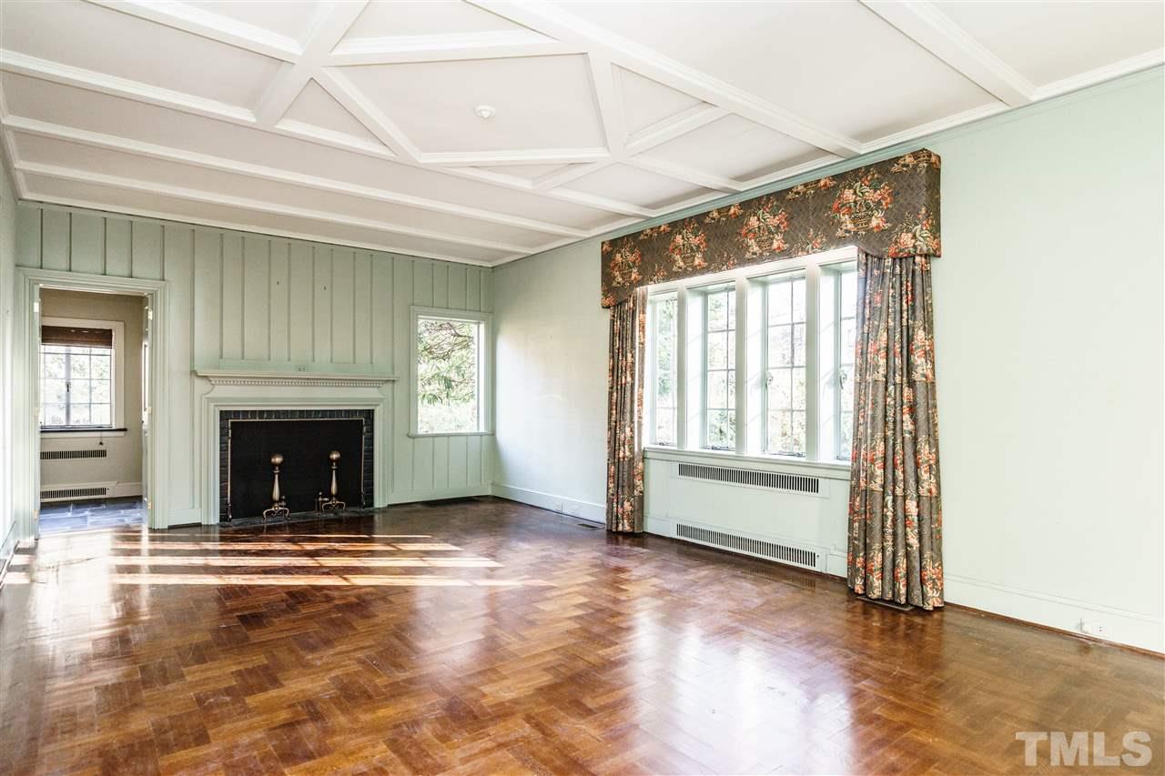 2515 White Oak Road Raleigh, NC 27609 - Photo 4 of 25 an empty room with wooden floor fireplace and windows
