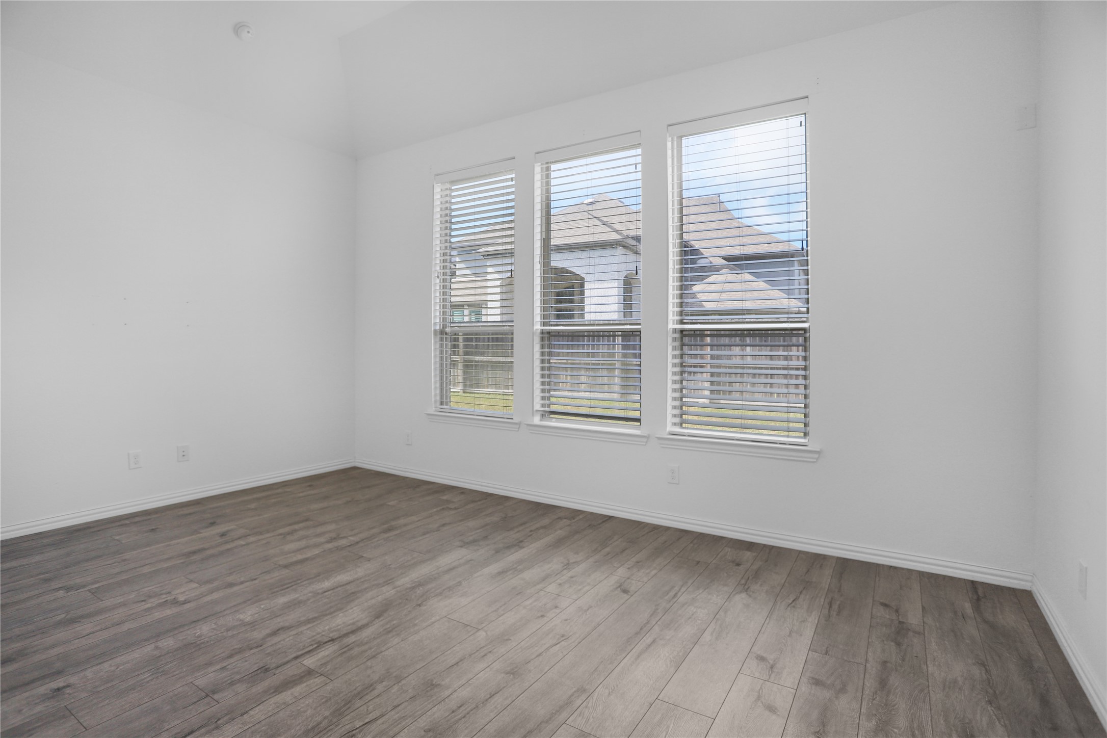 2718 Ripe Amber Cup Court Richmond, TX 77406 - Photo 13 of 43 an empty room with wooden floor and windows