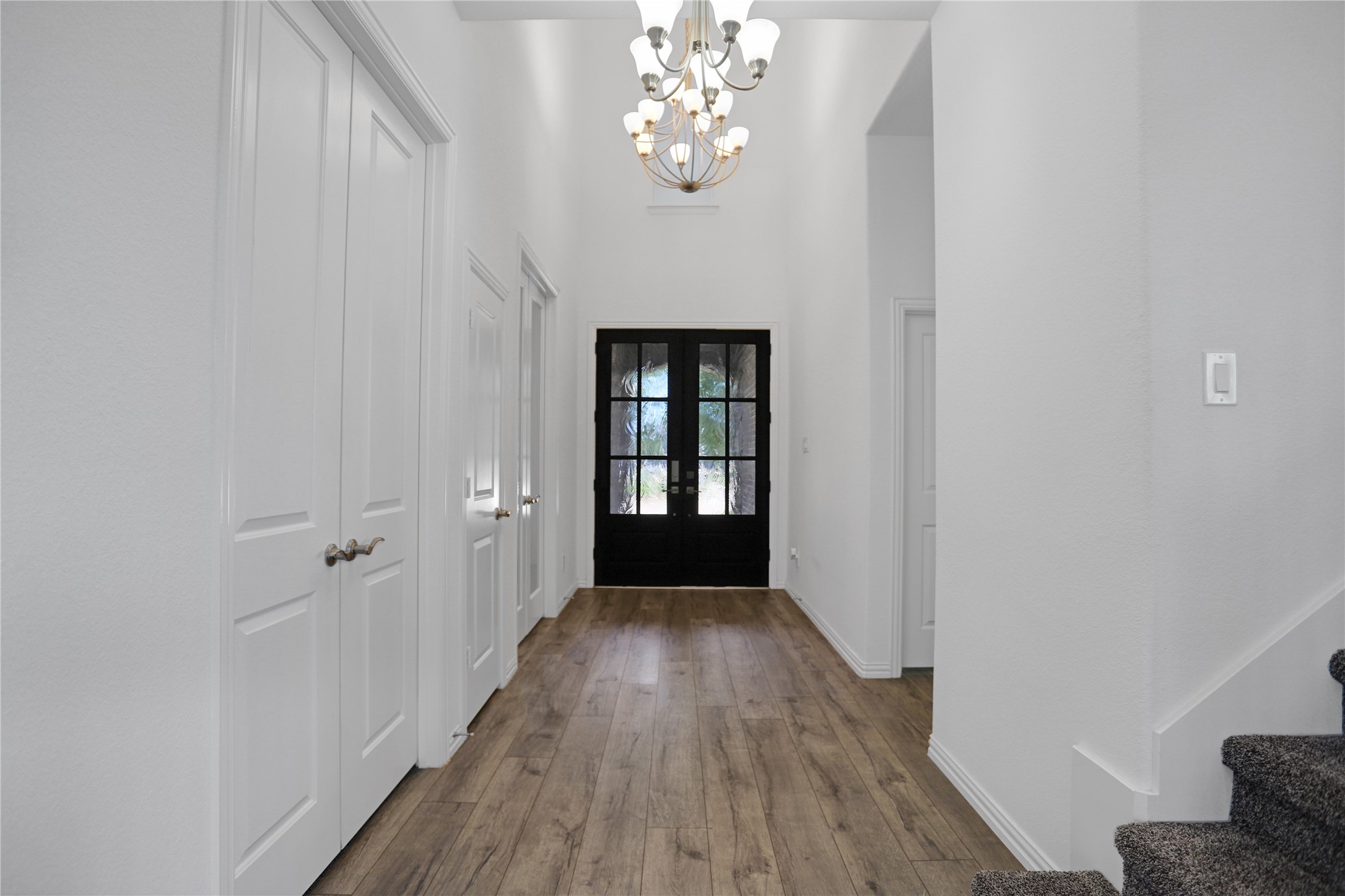 2718 Ripe Amber Cup Court Richmond, TX 77406 - Photo 3 of 43 a view of a hallway with wooden floor and a chandelier