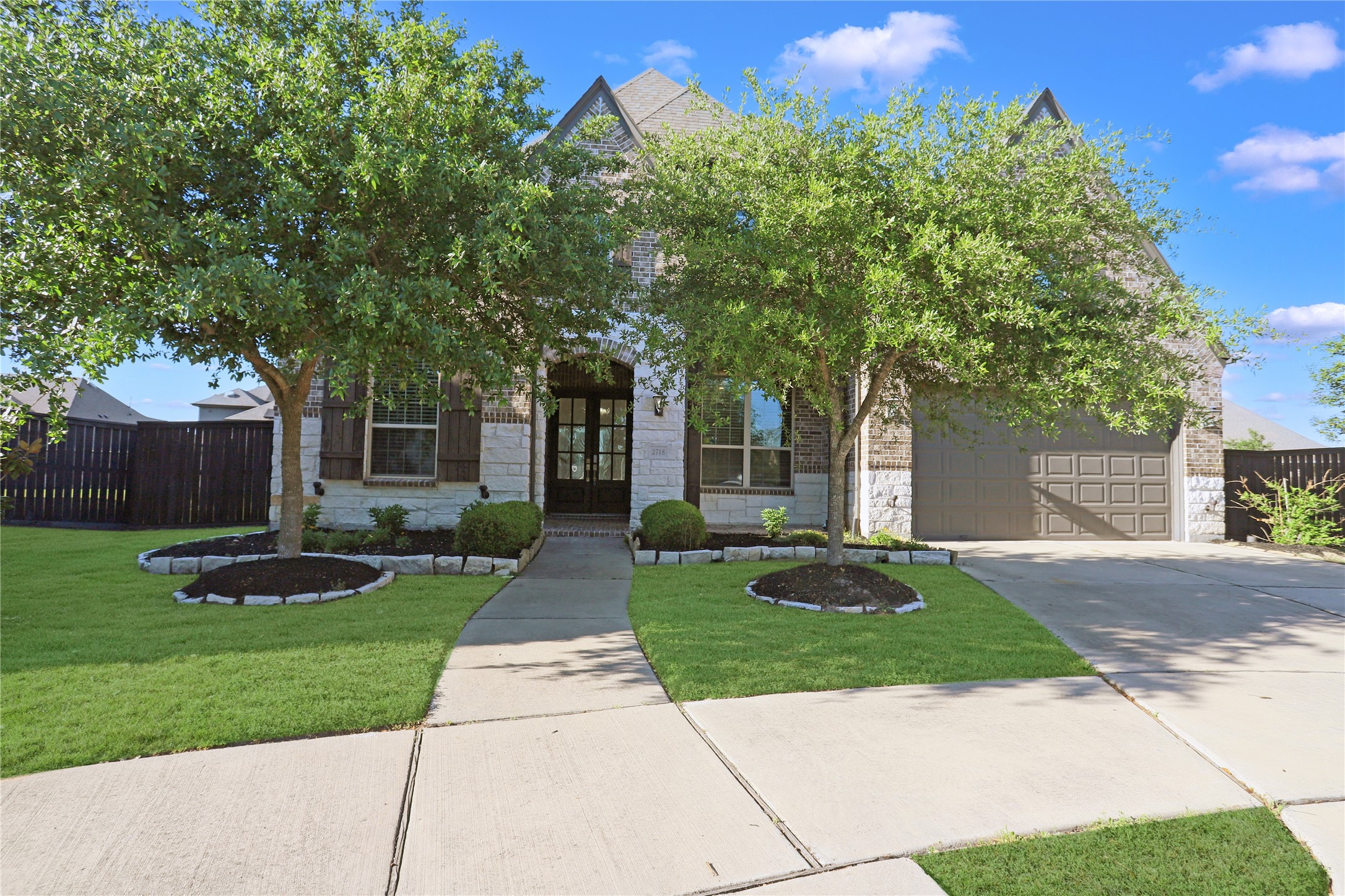 2718 Ripe Amber Cup Court Richmond, TX 77406 - Photo 39 of 43 a front view of a house with a yard and a garden