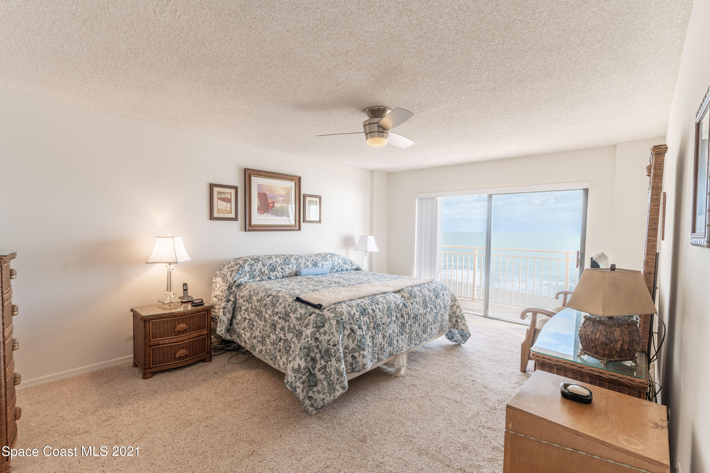 6770 Ridgewood Avenue, Unit 1002 Cocoa Beach, FL 32931 - Photo 12 of 16 a bedroom with a bed and a couch