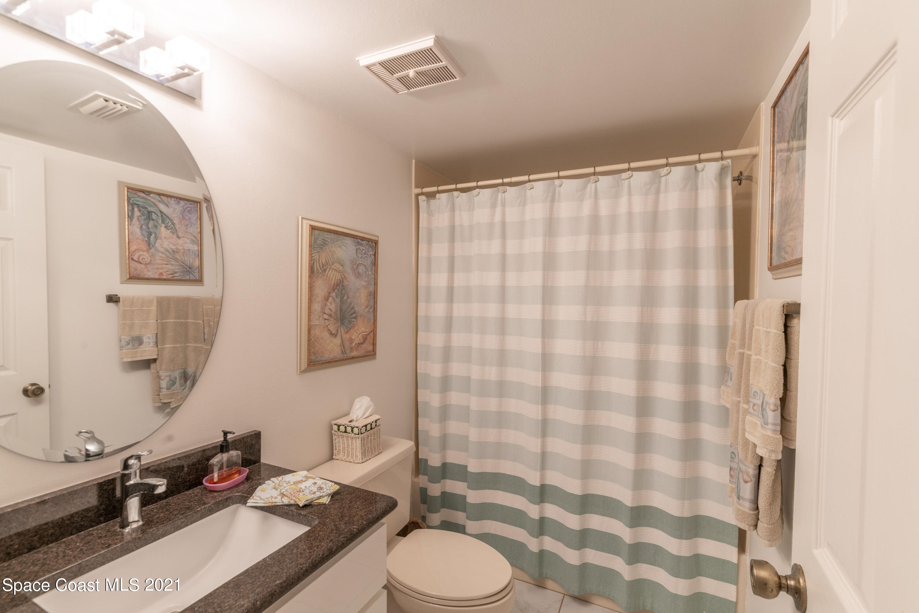 6770 Ridgewood Avenue, Unit 1002 Cocoa Beach, FL 32931 - Photo 16 of 16 a bathroom with a sink toilet and shower