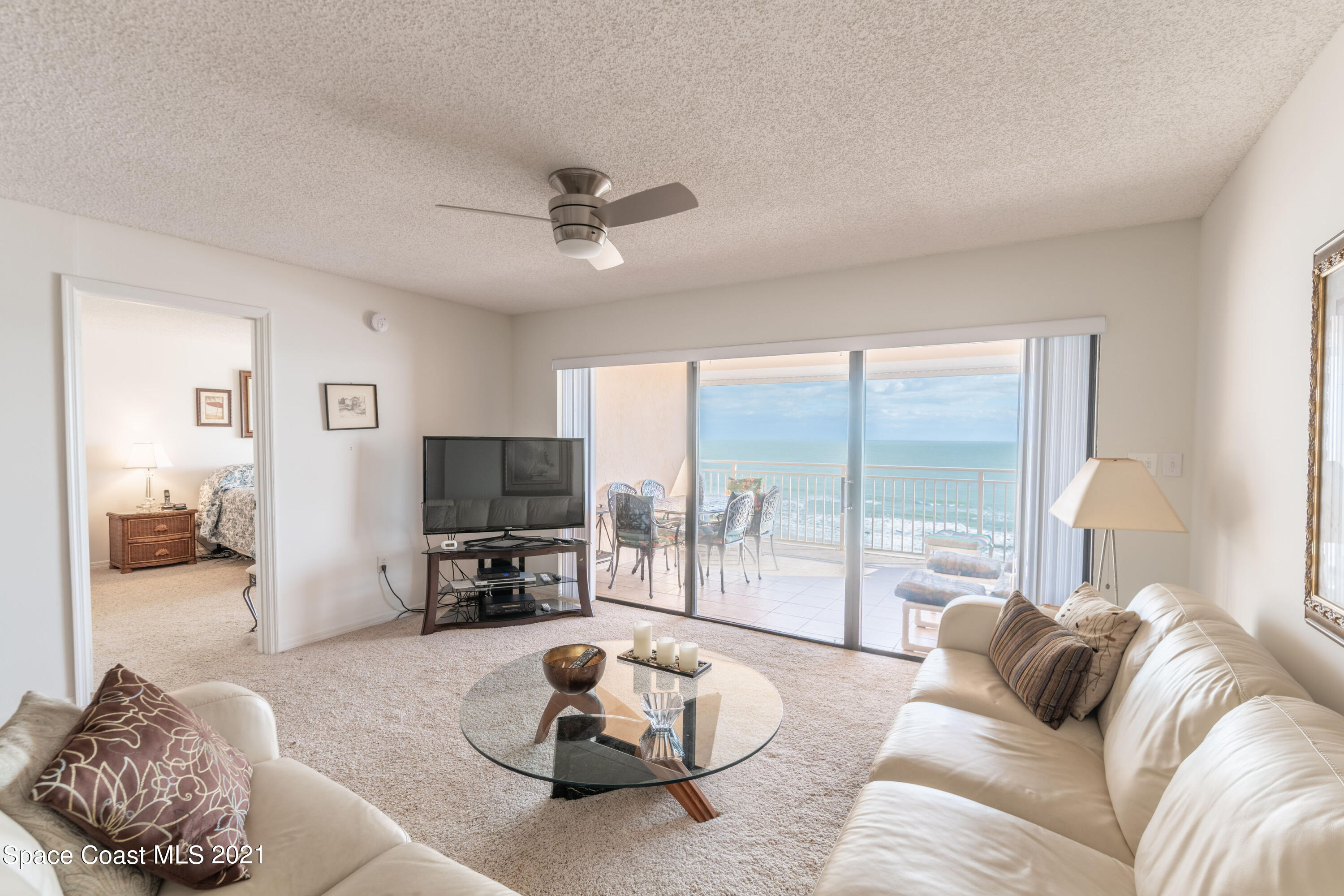 6770 Ridgewood Avenue, Unit 1002 Cocoa Beach, FL 32931 - Photo 7 of 16 a living room with furniture and a flat screen tv with wooden floor
