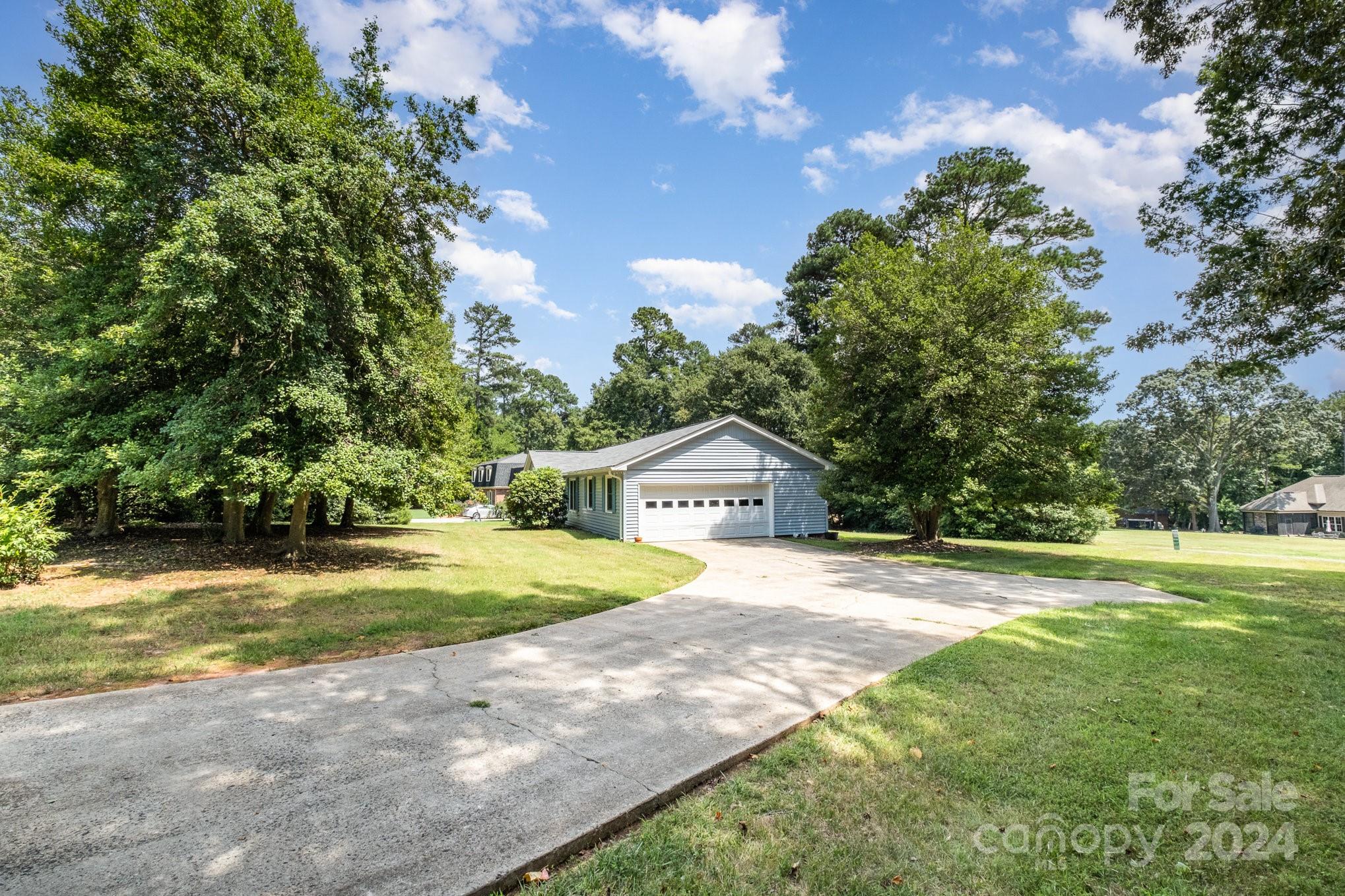 8208 Fairfield Forest Road Denver, NC 28037 - Photo 2 of 31 a view of a yard in front of a house with a large tree