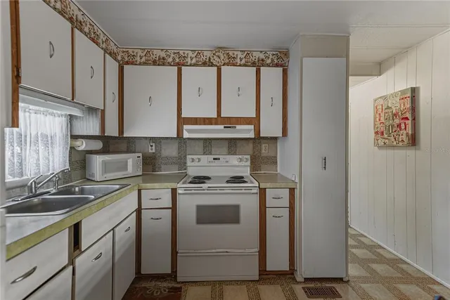 a kitchen with stainless steel appliances a stove a sink and a refrigerator