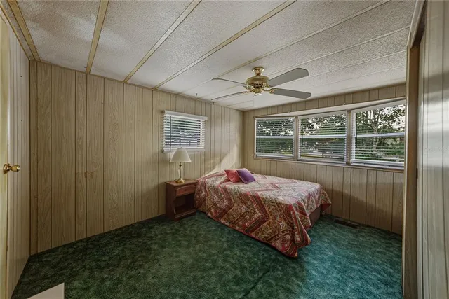 a bed sitting in a spacious bedroom next to a window