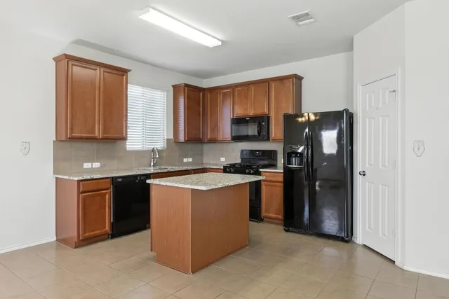a kitchen with stainless steel appliances granite countertop a refrigerator stove and sink