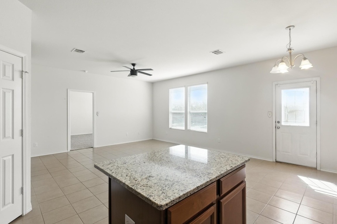 4617 Cleto Street Austin, TX 78725 - Photo 14 of 26 an empty room with a granite counter top and a chandelier
