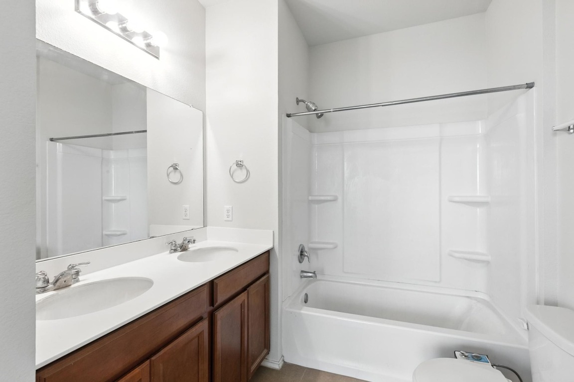 4617 Cleto Street Austin, TX 78725 - Photo 18 of 26 a bathroom with a tub sink shower and mirror