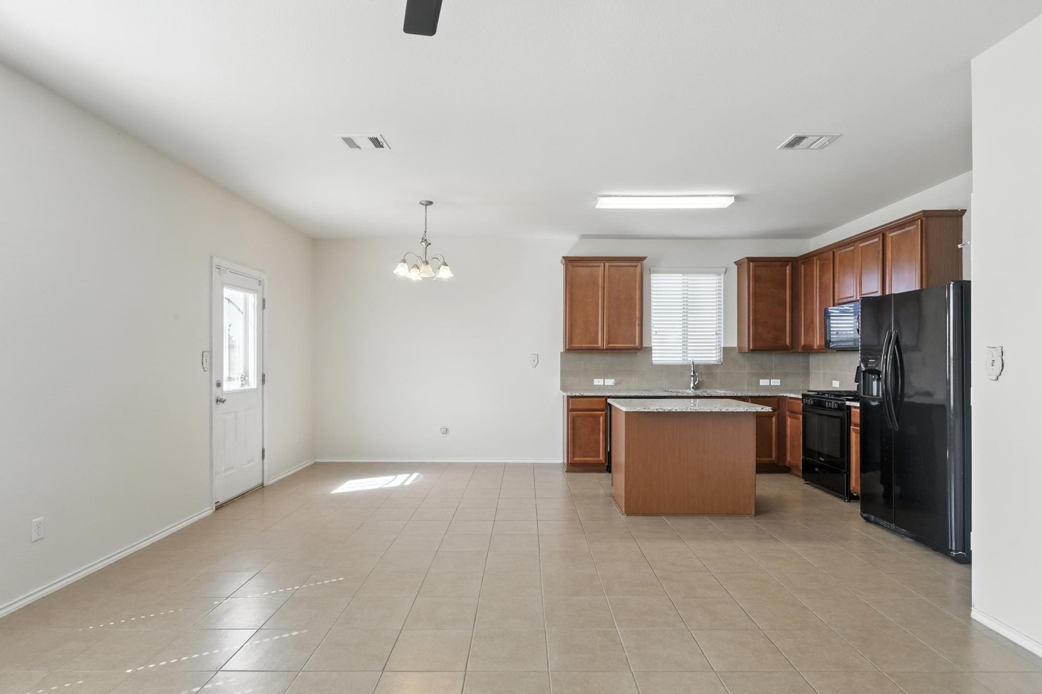 4617 Cleto Street Austin, TX 78725 - Photo 3 of 26 a large kitchen with a refrigerator and a stove top oven