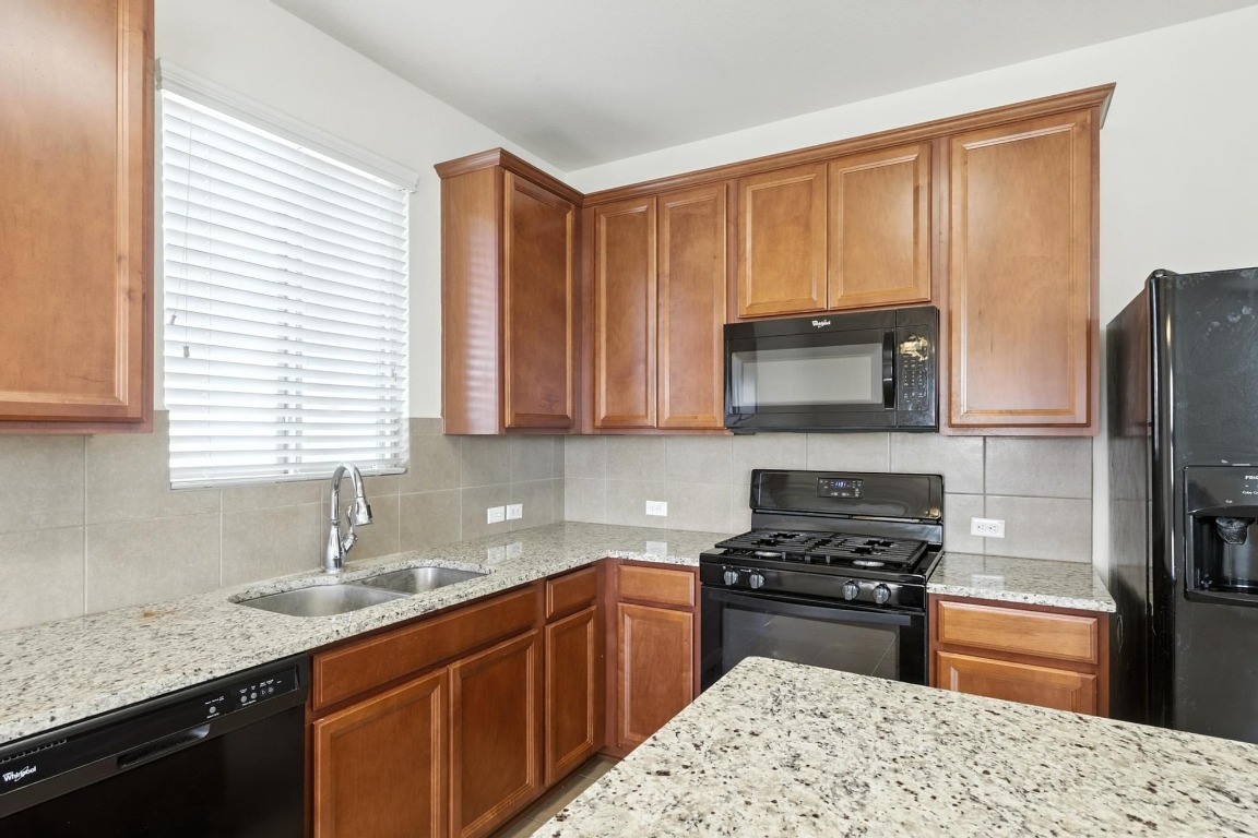 4617 Cleto Street Austin, TX 78725 - Photo 4 of 26 a kitchen with stainless steel appliances granite countertop a stove a sink dishwasher a refrigerator and a microwave oven with granite countertops