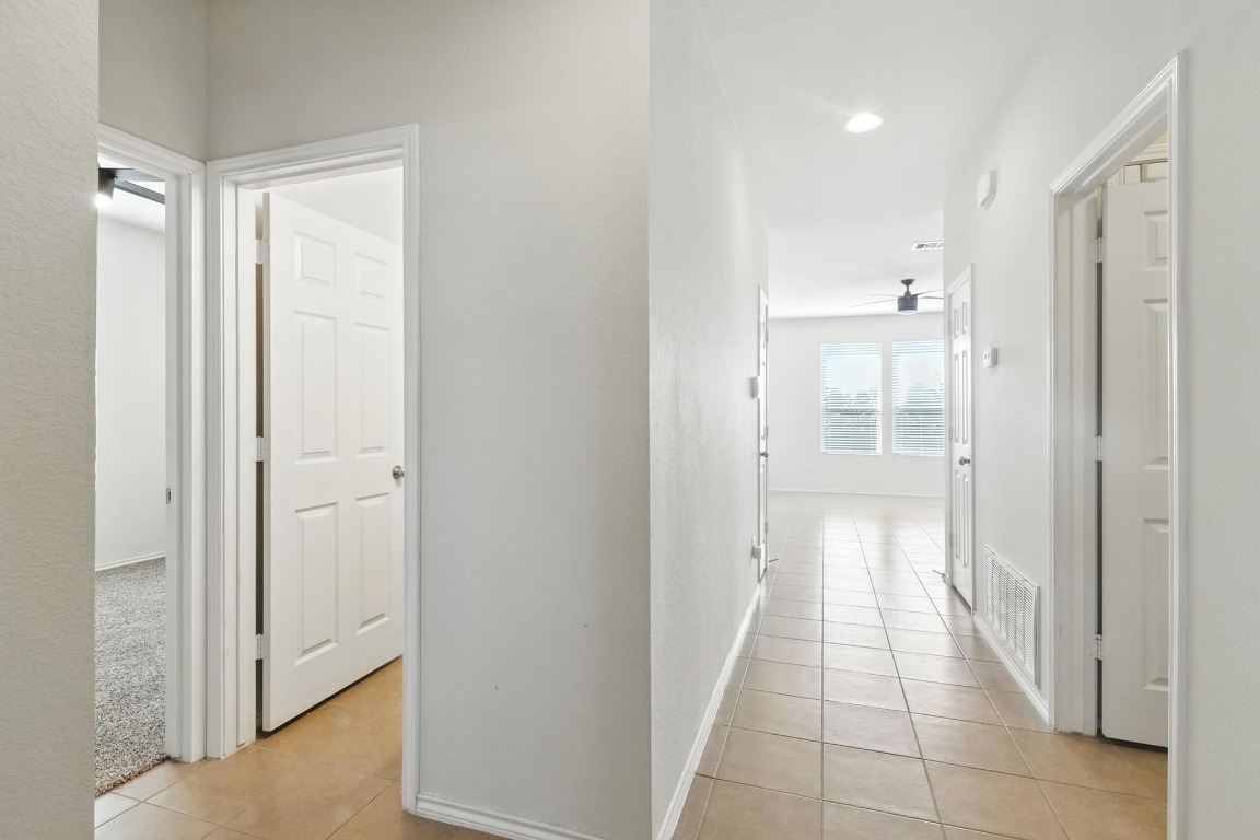 4617 Cleto Street Austin, TX 78725 - Photo 9 of 26 a view of a hallway with wooden shelves