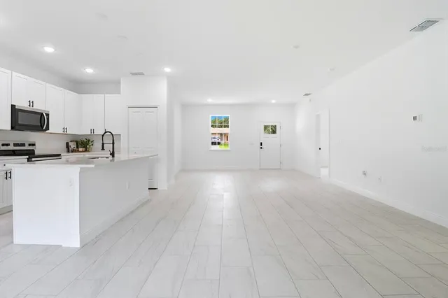 a kitchen with stainless steel appliances a refrigerator sink and white cabinets