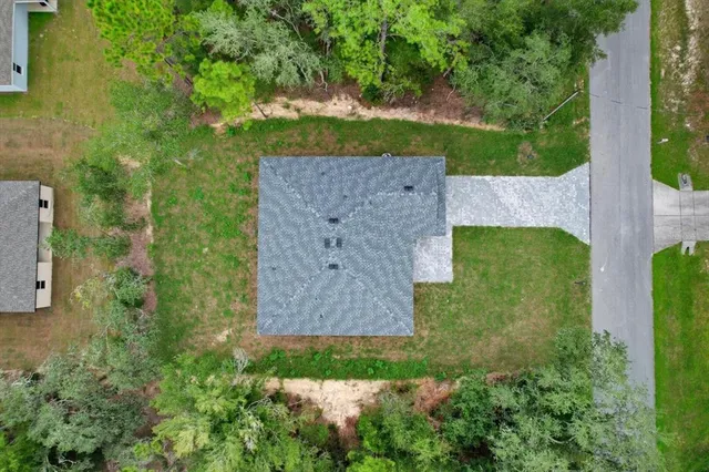 an aerial view of a house with a garden and yard