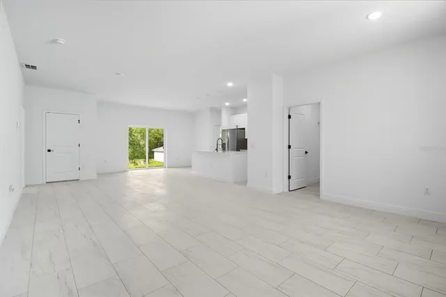 a view of a kitchen with cabinets stainless steel appliances wooden floor and a window