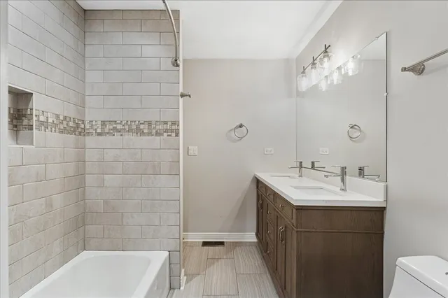 a bathroom with a double vanity sink a large mirror and shower