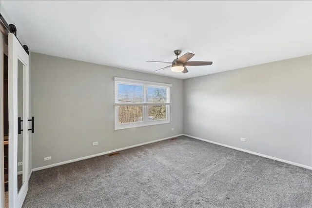 a view of a room with window and ceiling fan