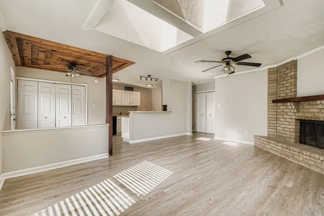 a view of an empty room with a fireplace and a window