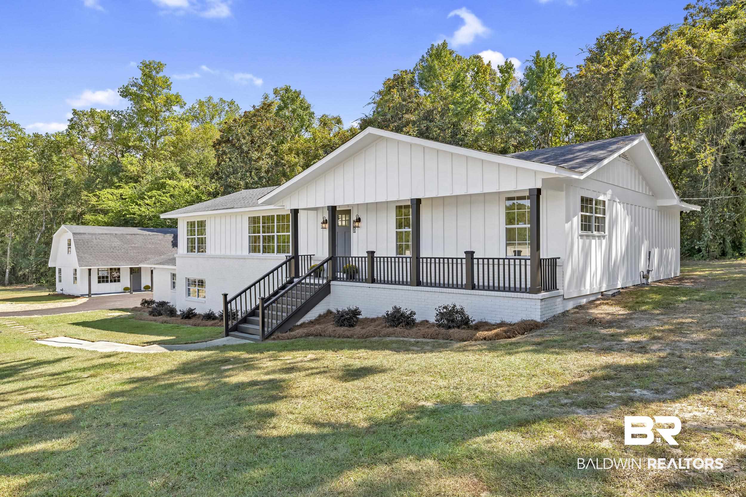 8351 Theodore Dawes Road Theodore, AL 36582 - Photo 3 of 46 View of front facade featuring a porch, board and batten siding, a front yard, and a shingled roof