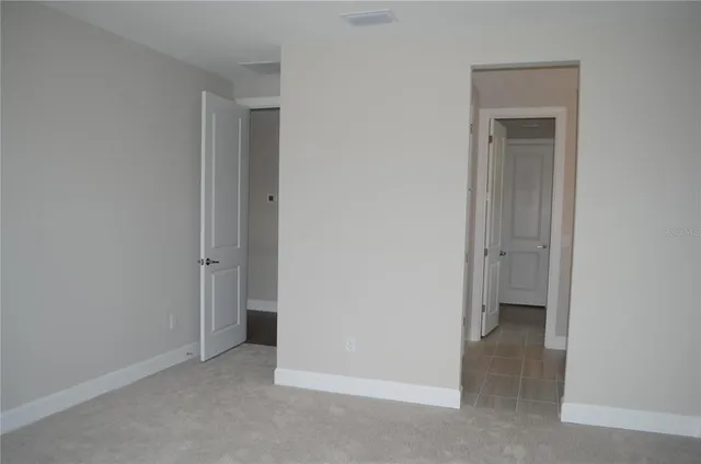 a view of a hallway with wooden floor and stairs