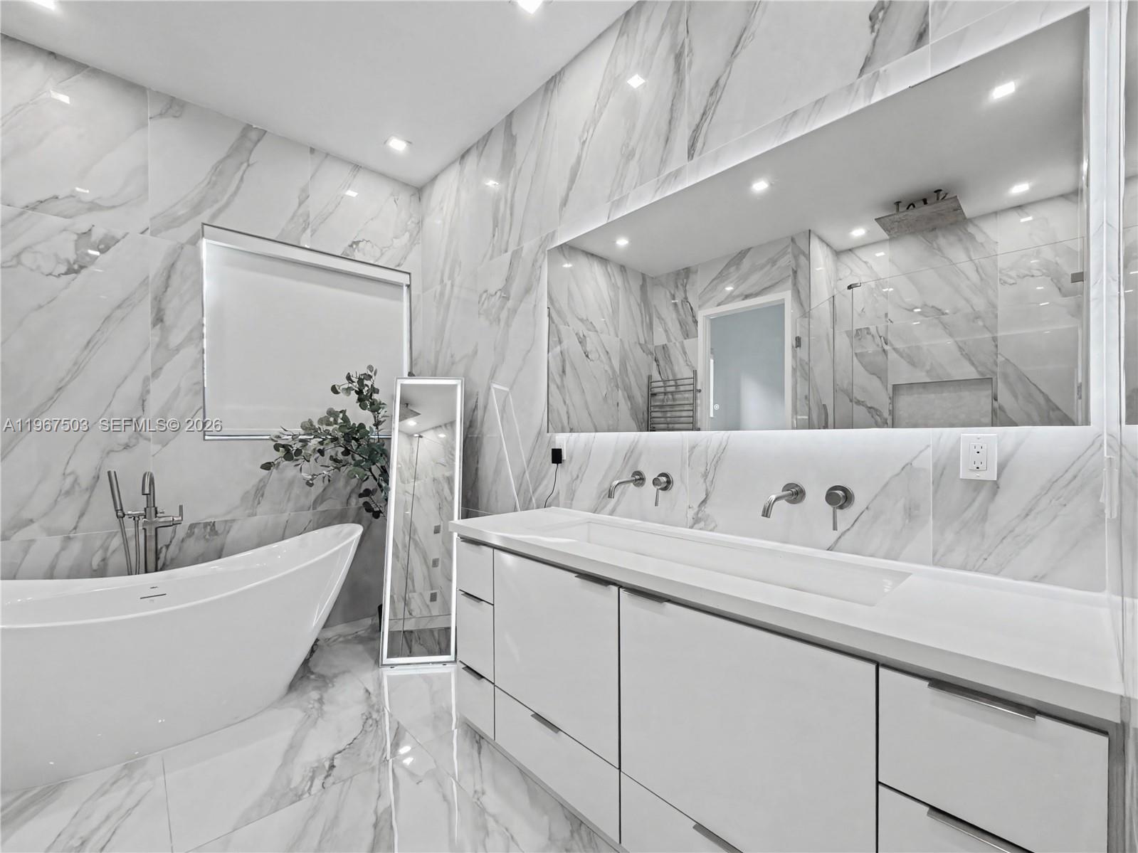 7733 Southwest 193rd Street Cutler Bay, FL 33157 - Photo 14 of 36 a bathroom with a bathtub a sink and a mirror