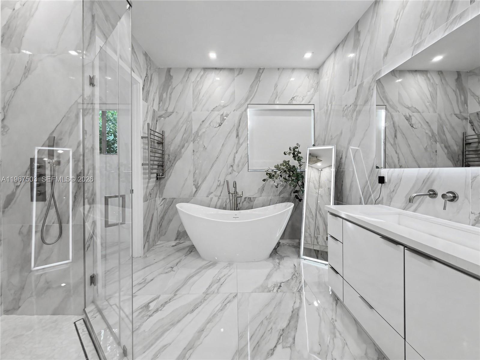 7733 Southwest 193rd Street Cutler Bay, FL 33157 - Photo 15 of 36 a spacious bathroom with a double vanity sink a large mirror and shower