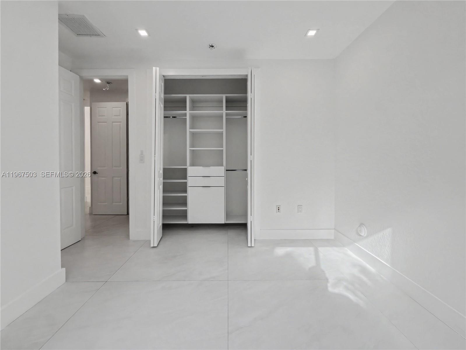 7733 Southwest 193rd Street Cutler Bay, FL 33157 - Photo 20 of 36 an empty room with a closet and mirrors