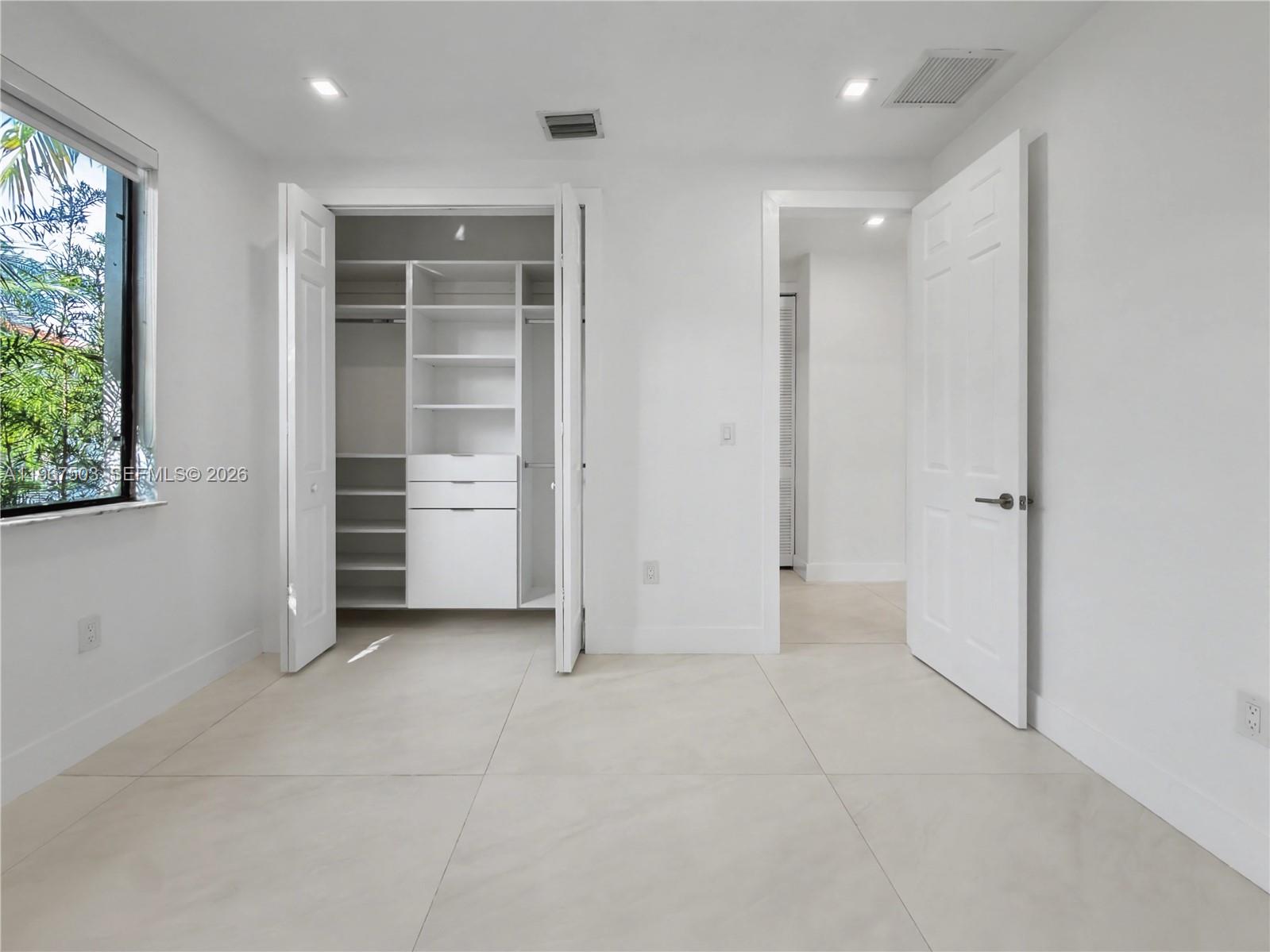 7733 Southwest 193rd Street Cutler Bay, FL 33157 - Photo 25 of 36 an empty room with closet and windows