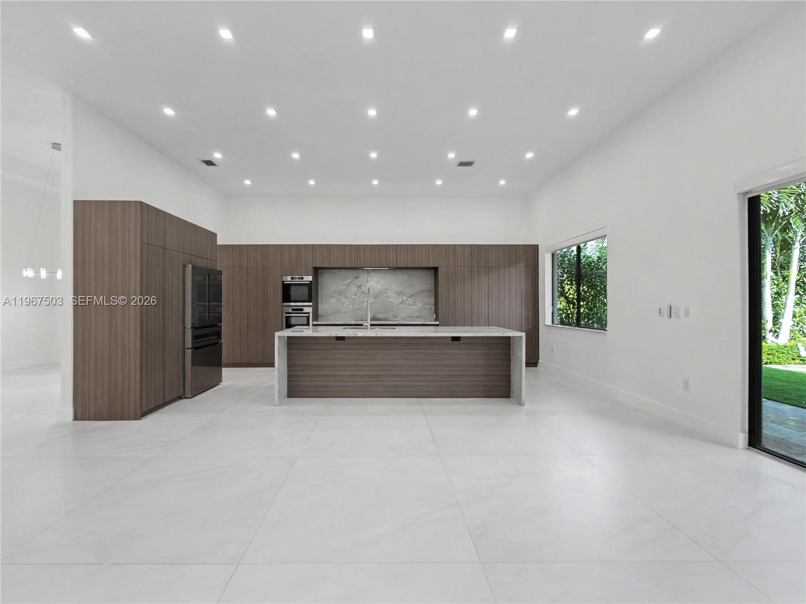 7733 Southwest 193rd Street Cutler Bay, FL 33157 - Photo 8 of 36 a large kitchen with stainless steel appliances a large counter top a oven and a refrigerator
