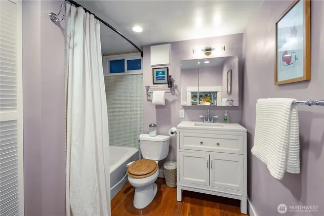 a bathroom with a toilet sink vanity and mirror