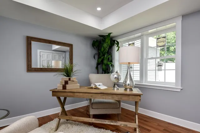a view of a workspace room with furniture and window