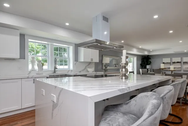 a kitchen with granite countertop a sink a counter space appliances and cabinets