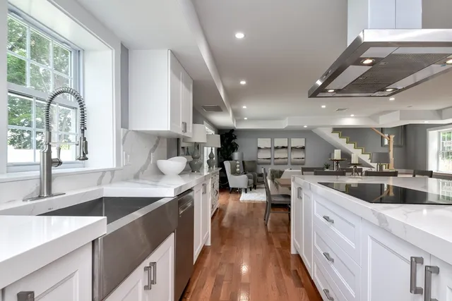 a kitchen with lots of counter top space a sink appliances and cabinets