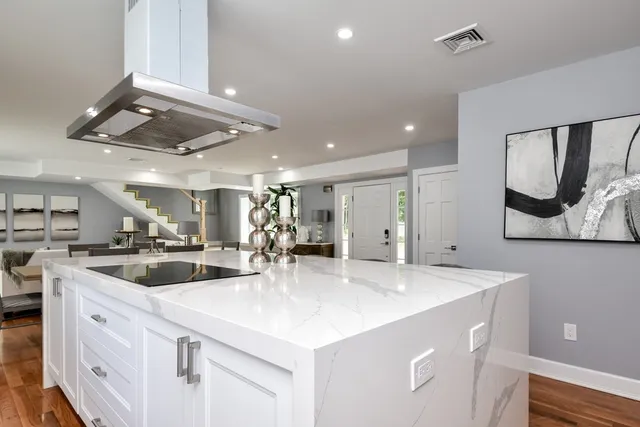 a kitchen with stainless steel appliances granite countertop a sink and a refrigerator