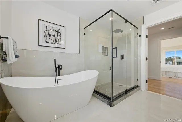 a spacious bathroom with a tub sink and mirror