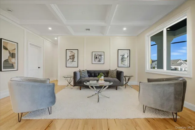 a living room with furniture a large window and dresser